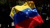 Un manifestante sostiene una bandera de Venezuela en medio de una protesta para exigir reivindicaciones salariales y laborales en Caracas, Venezuela el 1 de mayo de 2023. 