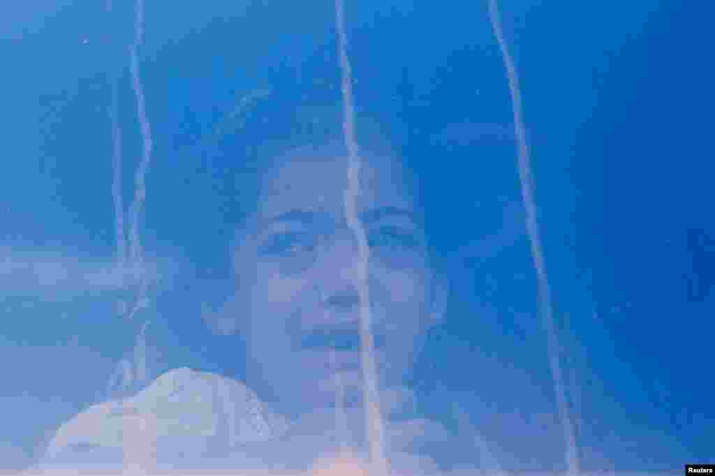 A Palestinian girl cries while sitting inside a vehicle, before she is transferred for treatment abroad without being accompanied by her parents, through the Kerem Shalom crossing, in Khan Younis in the southern Gaza Strip.
