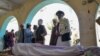 Relatives stand around the body of a victim of a suicide bomb attack during a funeral ceremony at a mosque in Kandahar on March 21, 2024. 