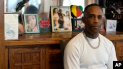 Damone Presley sits next to a memorial area in his house for his daughter, Nitosha, May 4, 2023, in St. Paul, Minn. Nitosha and three friends were found shot to death inside an SUV in the middle of a Wisconsin cornfield.