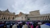 FILE - People crowd St. Peter's Square at the Vatican as Pope Francis delivers his blessing as he recites the Angelus noon prayer from the window of his studio, Feb. 26, 2023.