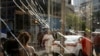 People are seen through a broken window next to the scene of an explosive drone attack in Tel Aviv, Israel, July 19, 2024. Yemen's Houthi rebels claimed responsibility for a drone believed to have exploded above Tel Aviv early Friday, leaving one dead.