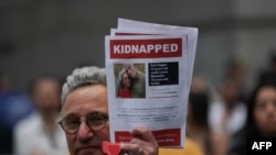 Seorang pendukung Israel memegang kertas berisi informasi warga yang disandera oleh Hamas dalam aksi unjuk rasa di New York pada 26 Oktober 2023. (Foto: AFP/Bryan R. Smith)