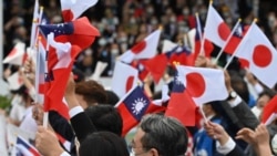 台灣與日本的國會議員在台北參加雙十節慶典時揮舞台灣與日本旗幟。 （2022年10月10日）