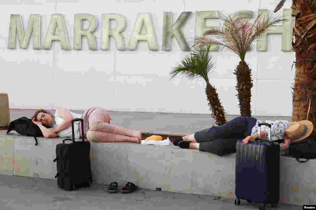 A las afueras del aeropuerto de Marrakech-Menara, personas descansan a la espera de sus vuelos tras el fuerte terremoto. 