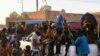 Des migrants sont assis à l'arrière d'un pick-up quelques minutes avant de se rendre à la frontière libyenne à Agadez, le 2 janvier 2024.