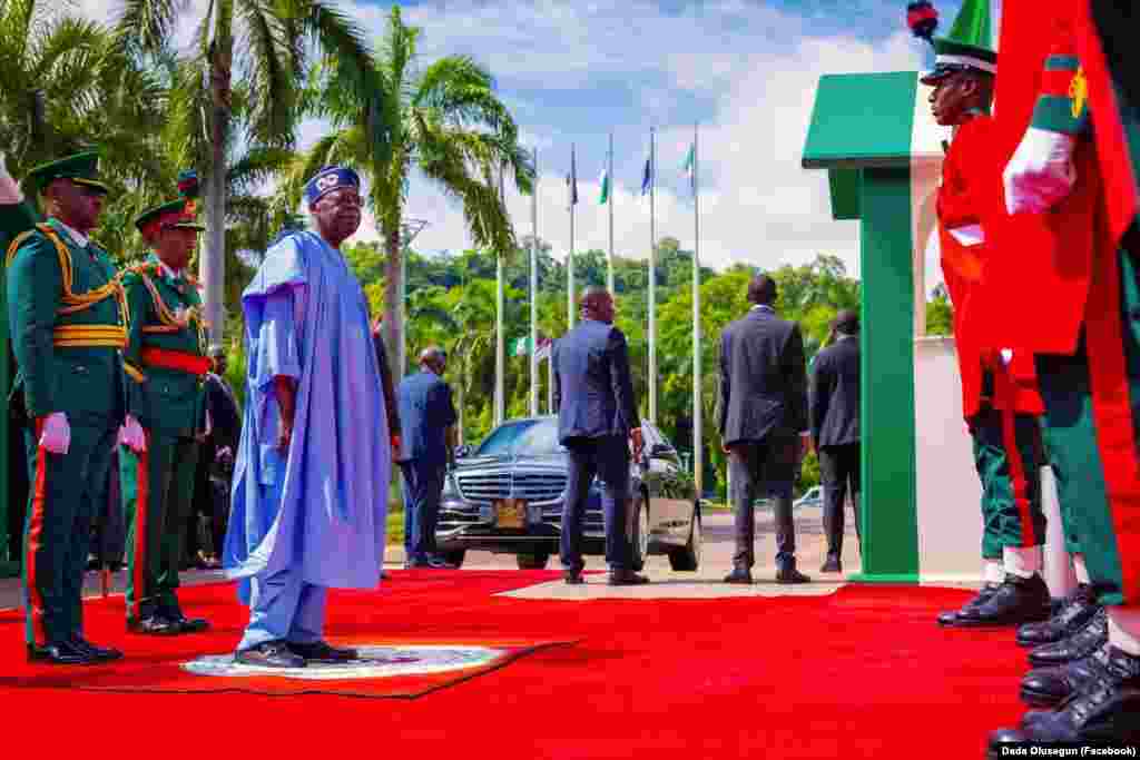 Shugaban Najeriya Bola Ahmed Tinubu yana duba jami'an tsaro a faretin bikin ranar dimokuradiyya a fadarsa