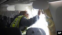 Petugas dari Badan Keselamatan Transportasi AS (NTSB) memeriksa kabin pesawat Alaska Airlines 1282 pada 7 Januari 2024. Pesawat tersebut mengalami insiden copotnya panel saat penerbangan berlangsung. (Foto: NTSB via AP)