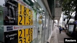 Un tablero que muestra el tipo de cambio del peso mexicano y el dólar estadounidense se ve en un banco en la Ciudad de México, México, 14 de noviembre de 2016.