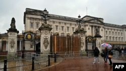 Orang-orang berjalan melewati gerbang Istana Buckingham di London, Minggu 10 Maret 2024, setelah sebuah mobil menabrak gerbangnya.