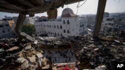 Palestinians look at a damaged residential building after an Israeli strike in Rafah, southern Gaza Strip, Jan. 10, 2024. 