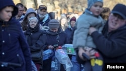Sejumlah warga lokal mengantre untuk mendapatkan air setelah serangan Rusia yang menghantam sejumlah wilayah di Kyiv membuat pasokan air bagi warga terputus. Antrean tampak mengular di Kyiv, pada 31 Oktober 2022. (Foto: Reuters/Gleb Garanich) 