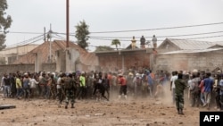 Des soldats des forces armées de la République démocratique du Congo tentent de contrôler une foule de manifestants prenant d'assaut une base de l'opération de maintien de la paix de l'ONU, la MONUSCO, à Goma, le 26 juillet 2022.