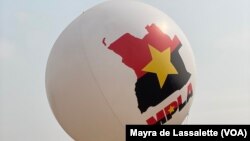 Um jovem carrega um balão com o mapa de Angola e o símbolo e cores do partido MPLA. Camama, Luanda. 
