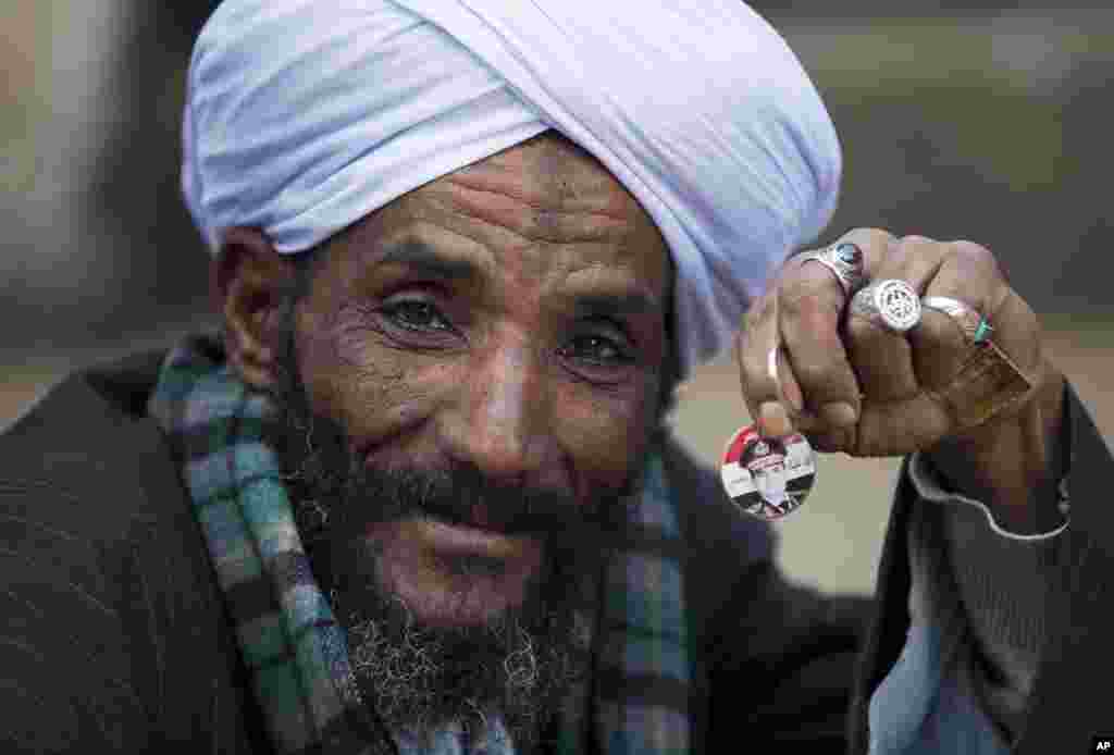 A man holds a pin with a picture of Egypt's Defense Minister Gen. Abdel-Fattah el-Sissi as he waits for his turn to cast his vote in the country's constitutional referendum in Cairo.