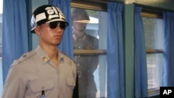 在朝鮮半島北緯三十八度停戰線上的板門店非軍事區，韓國憲兵在聯合國休戰村站崗，朝鮮一名士兵在窗後觀察。（資料照片）