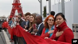 Climate activists carry a red banner during a demonstration at the COP21, United Nations Climate Change Conference, in Le Bourget, north of Paris, Friday, Dec. 11, 2015. (AP Photo/Michel Euler)