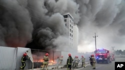 Petugas pemadam kebakaran berusaha memadamkan kobaran api di sebuah bangunan pasca serangan artileri Rusia di Kyiv, Ukraina, Kamis (3/3). 