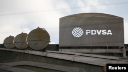ARCHIVO: Recortes que muestran imágenes de operaciones petroleras afuera de un edificio de la petrolera estatal venezolana PDVSA en Caracas, Venezuela, el 28 de enero de 2019.