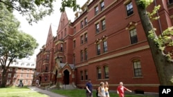Sejumlah orang tampak berjalan di lingkungan kampus Universitas Harvard di Cambridge, Massachusetts, pada 16 Juli 2019. (Foto: AP/Steven Senne)