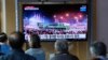 People watch a TV screen showing a news report about North Korea's military parade, at a train station in Seoul, South Korea, April 26, 2022.