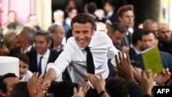 Le président français et candidat à la réélection Emmanuel Macron serre la main de ses partisans alors qu'il organise un rassemblement le dernier jour de la campagne, à Figeac, dans le sud de la France, le 22 avril 2022.