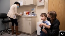 FILE - Ilana Diener holds her son, Hudson, 3, during an appointment for a Moderna COVID-19 vaccine trial in Commack, N.Y. on Nov. 30, 2021.
