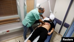 A patient suffering from Long COVID is examined in the post-coronavirus disease (COVID-19) clinic of Ichilov Hospital in Tel Aviv, Israel, February 21, 2022. (REUTERS/Amir Cohen)