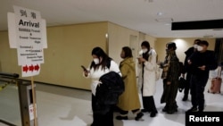 Wasafiri waliowasili na ndege kutoka mji mkuu wa Beijing wakielekea kupima Covid -19 katika uwanja wa ndege wa kimataifa wa mashariki mwa Tokyo, Japan, January 8, 2023. REUTERS/Kim Kyung-Hoon