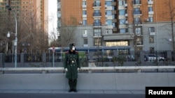 A member of the Chinese People's Armed Police Force wears a face mask as he keeps watch on a street amid COVID-19 outbreaks in Beijing, Dec. 1, 2022.