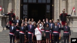 Peruvian President Dina Boluarte, center front, and newly named cabinet members wave as after their swearing-in ceremony on the steps of the government palace in Lima, Peru, Dec. 10, 2022. Boluarte asked each minister to pledge to work "without committing acts of corruption." 