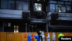 Para petugas medis tampak mengenakan baju hazmat ketika bekerja di area permukiman yang tengah menjalani lockdown di Shanghai, China, pada 25 Maret 2022. (Foto: Reuters/Aly Song)