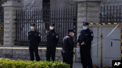 Chinese police officers stand watch outside the Beijing No.2 Intermediate People's Court before the trial of Chinese-Australian business reporter Cheng Lei on Thursday, March 31, 2022, in Beijing. 