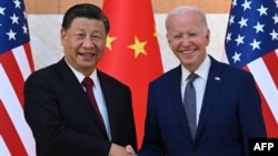 Presiden China Xi Jinping (kiri) dan Presiden AS Joe Biden berjabat tangan saat mereka bertemu di sela-sela KTT G-20 di Nusa Dua di Bali, hari Senin 14 November 2022.