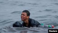 Achraf, 16, plače dok pliva koristeći flaše kao plovke, blizu ograde između špansko-marokanske granice, nakon što su hiljade migranata preplivale granicu, u Seuti, Španija, 19. maja 2021.