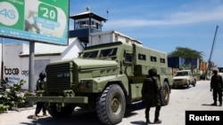 Des soldats de la paix de l'Union africaine se tiennent à côté d'un véhicule blindé de transport à Mogadiscio, en Somalie, le 27 avril 2022.