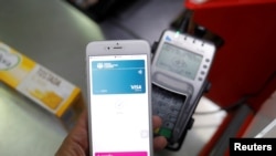FILE - A shopper uses the mobile payment service Apple Pay at a supermarket, in Ronda, southern Spain, Oct. 9, 2020. 
