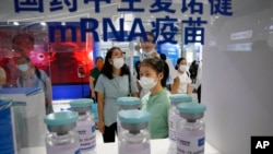 2021年9月5日，参观者在中国北京举行的中国国际服务贸易交易会上观看国药控股子公司CNBG使用mRNA技术生产的巨型COVID-19疫苗样本瓶。（美联社照片）
