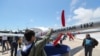 A young man looks at the Bayraktar TB2 drone, manufactured by Turkey's Baykar, as it is presented during the opening of the aerospace and technology festival 'Teknofest Azerbaijan' at Baku Crystal Hall in Baku, on May 27, 2022. 