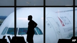 ARCHIVO - En esta foto del 18 de febrero de 2021, un pasajero usa una mascarilla para ayudar a prevenir la propagación del nuevo coronavirus mientras espera un vuelo de Delta Airlines en el Aeropuerto Internacional Hartsfield-Jackson en Atlanta.