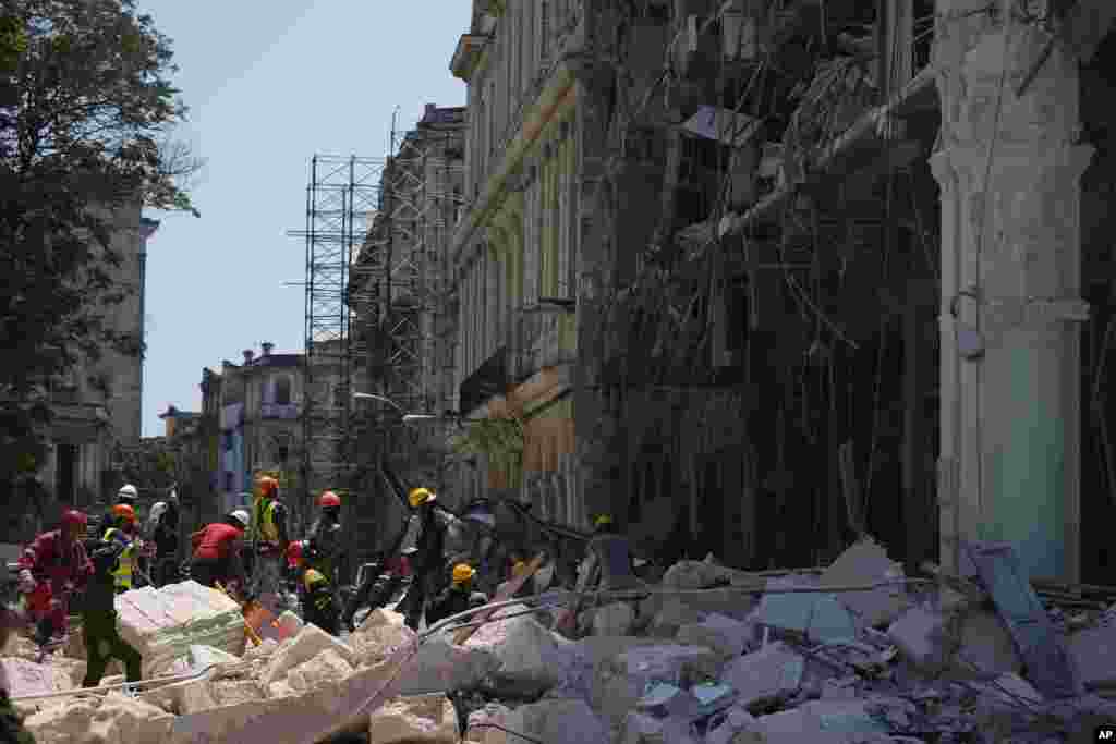 Trabajadores de emergencia caminan entre los escombros frente al Hotel Saratoga de cinco estrellas después de una explosión mortal en La Habana Vieja, Cuba, el viernes 6 de mayo de 2022.