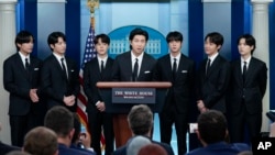 RM (mitan) ak lot manm sipegwoup K-Pop Koreyen BTS (de goch a dwat) V, Jungkook, Jimin, Jin, J-Hope ak Suga, pale pandan rankont ak jounalis ki kouri Lamezonblanch yo nan Washington, Madi 31 Me, 2022. 