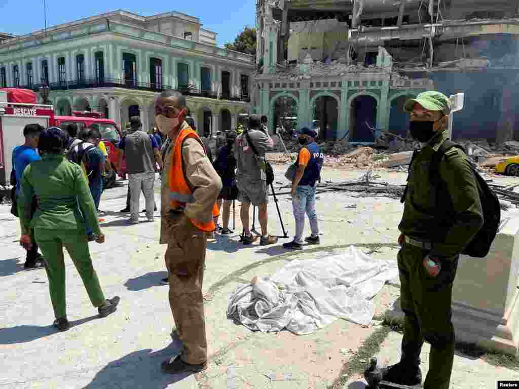 El cuerpo cubierto de una víctima yace en la calle después de que una explosión destruyera el Hotel Saratoga, en La Habana, Cuba, el 6 de mayo de 2022.