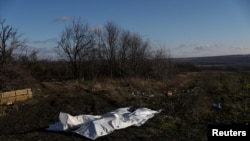 The bodies of dead Russian soldiers lay covered after being gathered by Ukrainian soldiers, to be exchanged for the bodies of fallen Ukrainian soldiers, in the former Russian occupied region of Donetsk Oblast, Ukraine, Dec. 14, 2022. 