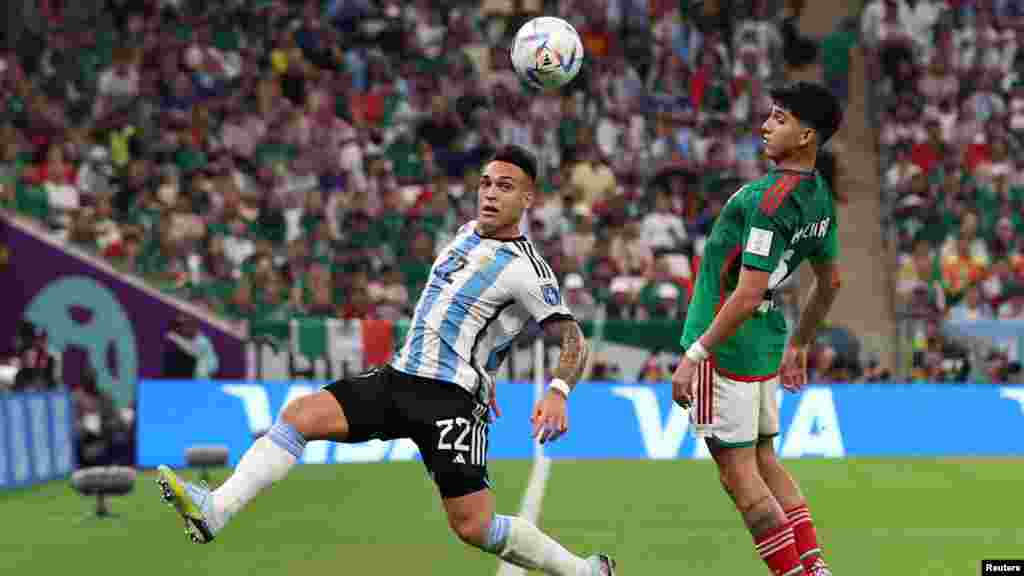 Ajanten Lautaro Martinez an aksyon ak Meksiken Kevin Alvarez pandan match Gwoup C Ajantin kont Meksik nan Mondyal Foutbol Qatar la, 26 Nov. 2022.