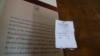 FILE - An Israeli army closure order hangs on a door of the Al-Haq human rights organization that was raided by Israel forces, in the West Bank city of Ramallah, Aug. 18, 2022. Israel raided offices of several Palestinian advocacy groups it had designated terrorist organizations.