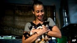 Grettel Montes de Oca Valdes, a professional dancer and founder of the group Cubans in Defense of Animals poses with four kittens that she has received in her house in Havana, Cuba, April 4, 2019. 