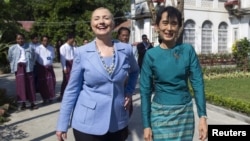  U.S. Secretary of State Hillary Clinton (L) and Myanmar's pro-democracy leader Aung San Suu Kyi tour the grounds after their meeting at Suu Kyi's house in Yangon December 2, 2011.