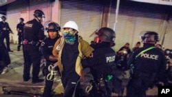 FILE - May 31, 2020 photo, Los Angeles police officers arrest a demonstrator in Los Angeles. The Los Angeles Police Department is investigating 56 allegations of misconduct during protests against police brutality in the wake of George Floyd's death.