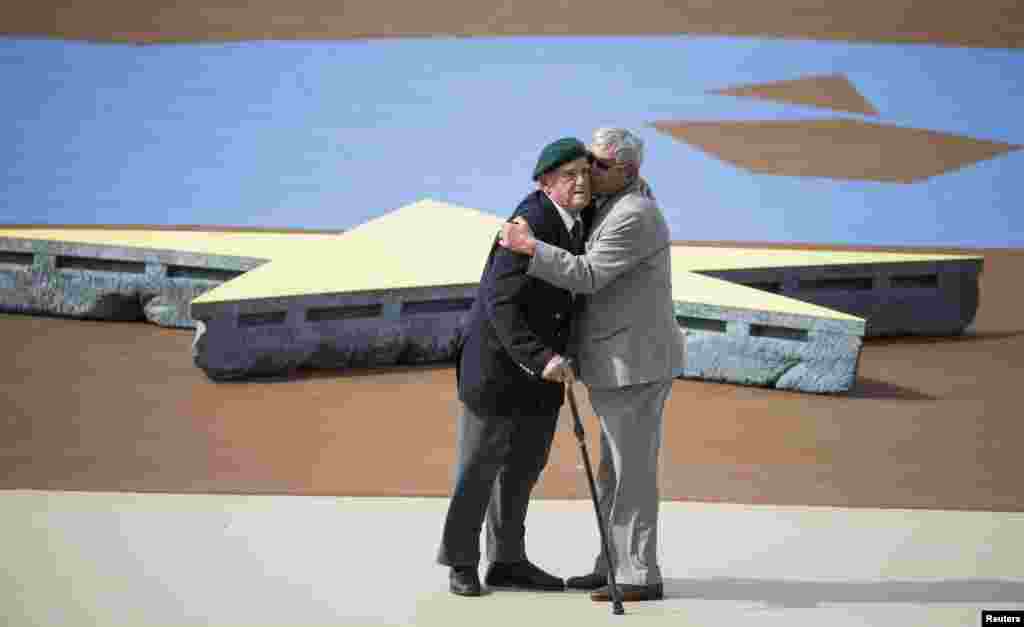 French WWII veteran Leon Gautier of the Kiieffer commando (L) and German WWII veteran, paratrooper Johannes Borner (R) embrace as a sign of reconciliation during an international ceremony marking the 70th anniversary of the Allied landings on D-Day on Sword Beach in Ouistreham, in Normandy, June 6, 2014.